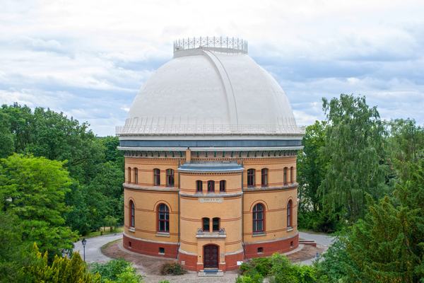 Rundes Gebäude mit Kuppel umringt von grünen Bäumen