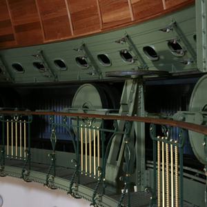 Grün gestrichene Metallkonstruktion und hölzernes Geländer mit grün-goldfarbenen vertikalen Stäben