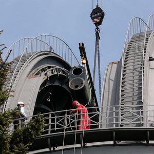 Geöffneter Kuppelspalt mit Teleskoprohr am Haken eines Krans