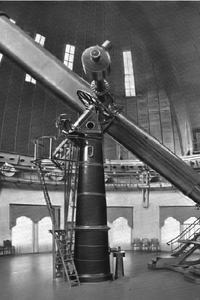 Schwarz-weiß-Foto eines langen Teleskops in einer Kuppel