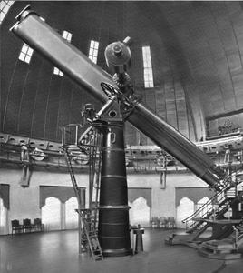 Schwarz-weiß-Foto eines langen Teleskops in einer Kuppel