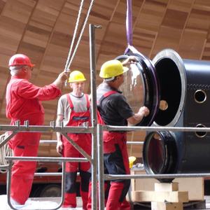 Bauarbeiter setzen eine große Linse in ein Rohr