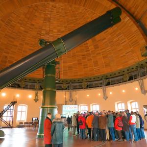 Großes Teleskop in Kuppelgebäude mit vielen Menschen